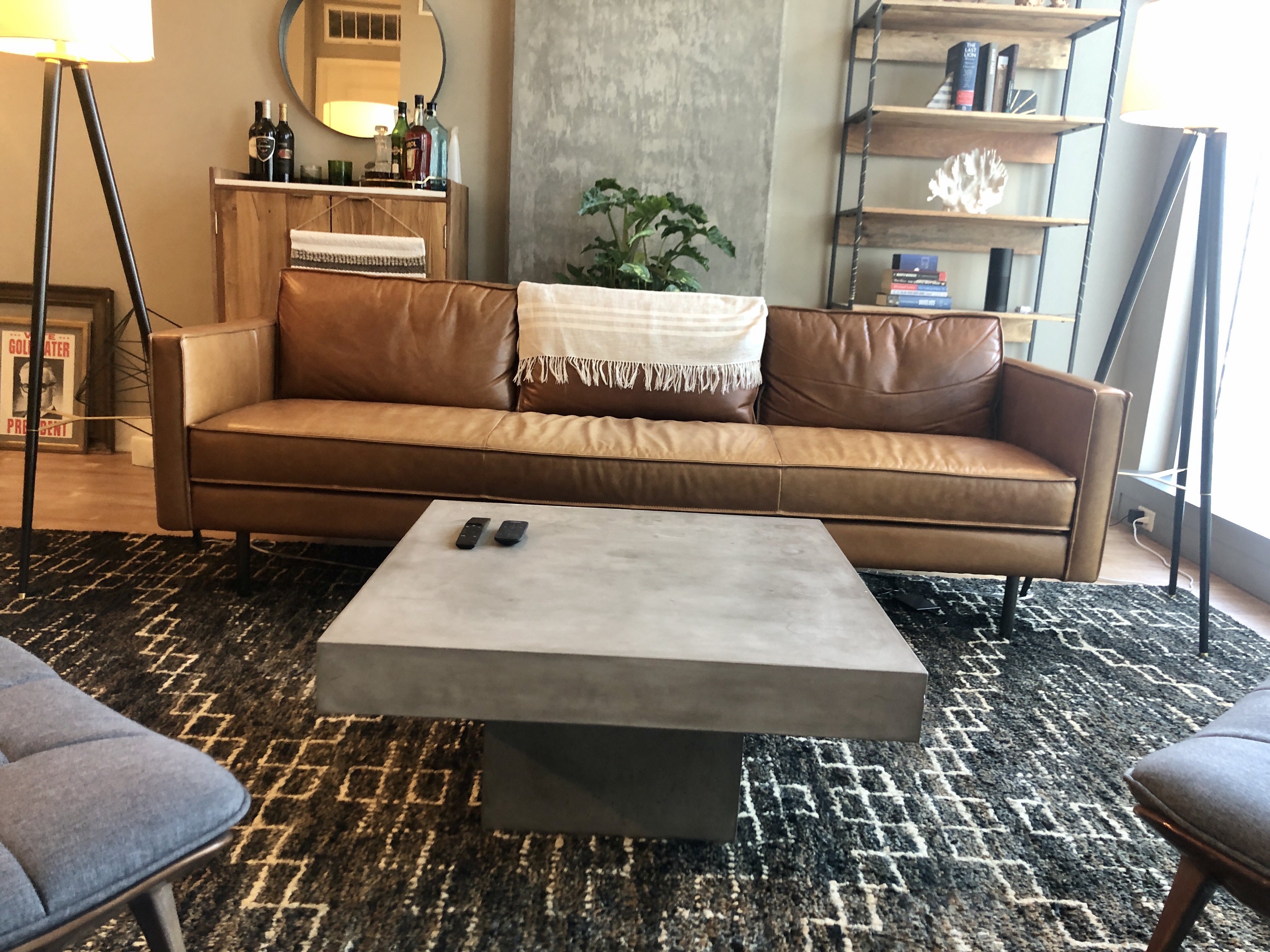 Leather couch with concrete coffee table and styled living room