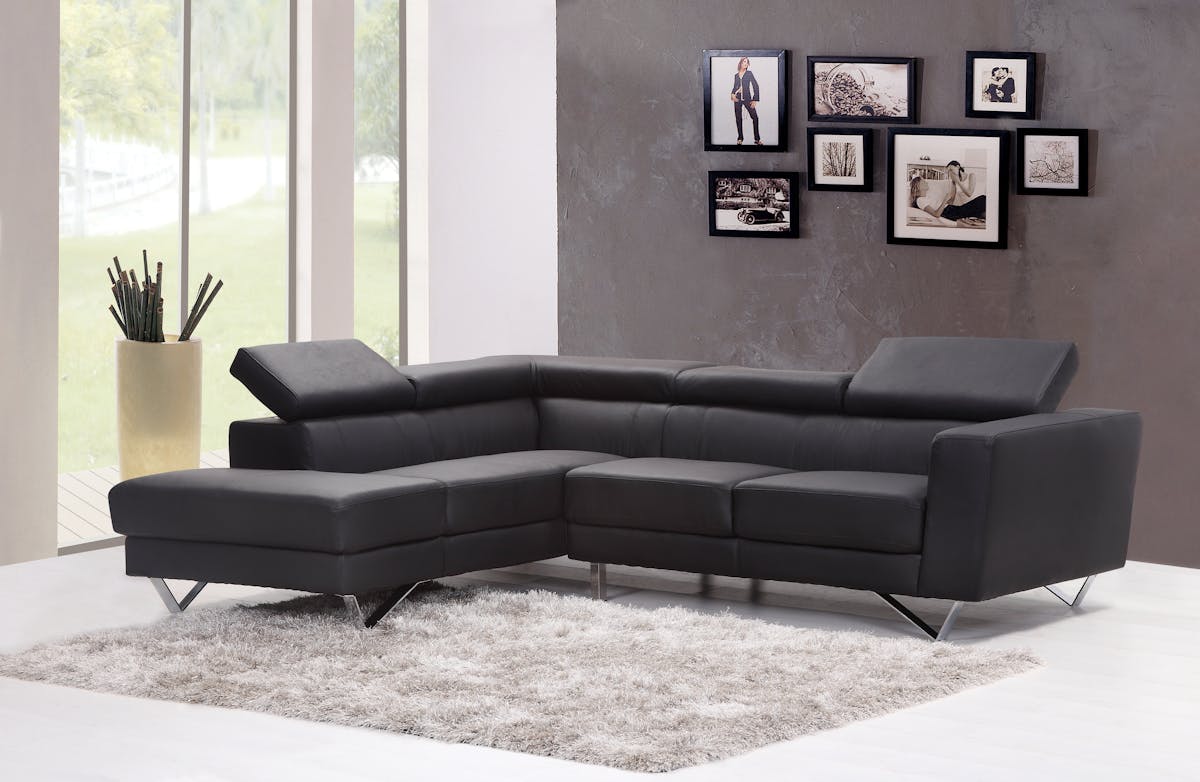 Well-designed male living room with leather couch, concrete coffee table, and balanced lighting